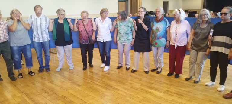 a group of older women holding a blue banner